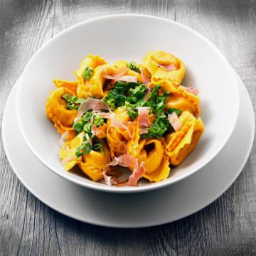 Tortellini con speck e spinaci